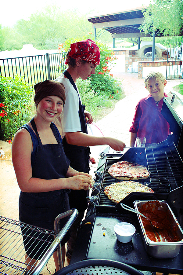 Grilling pizzas for a campus community gathering.